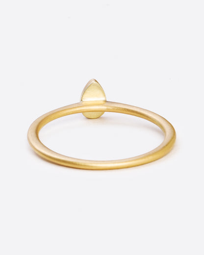 A yellow gold ring with a bezel set teardrop shaped diamond. Shown from the back.