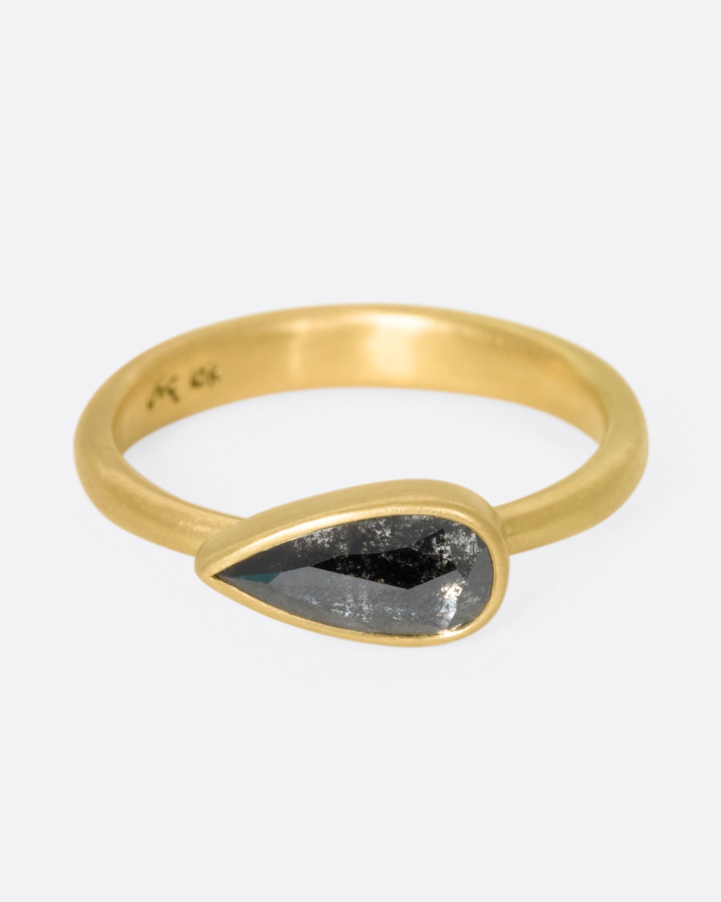 A solitaire ring with a dark, cloudy diamond set on its side