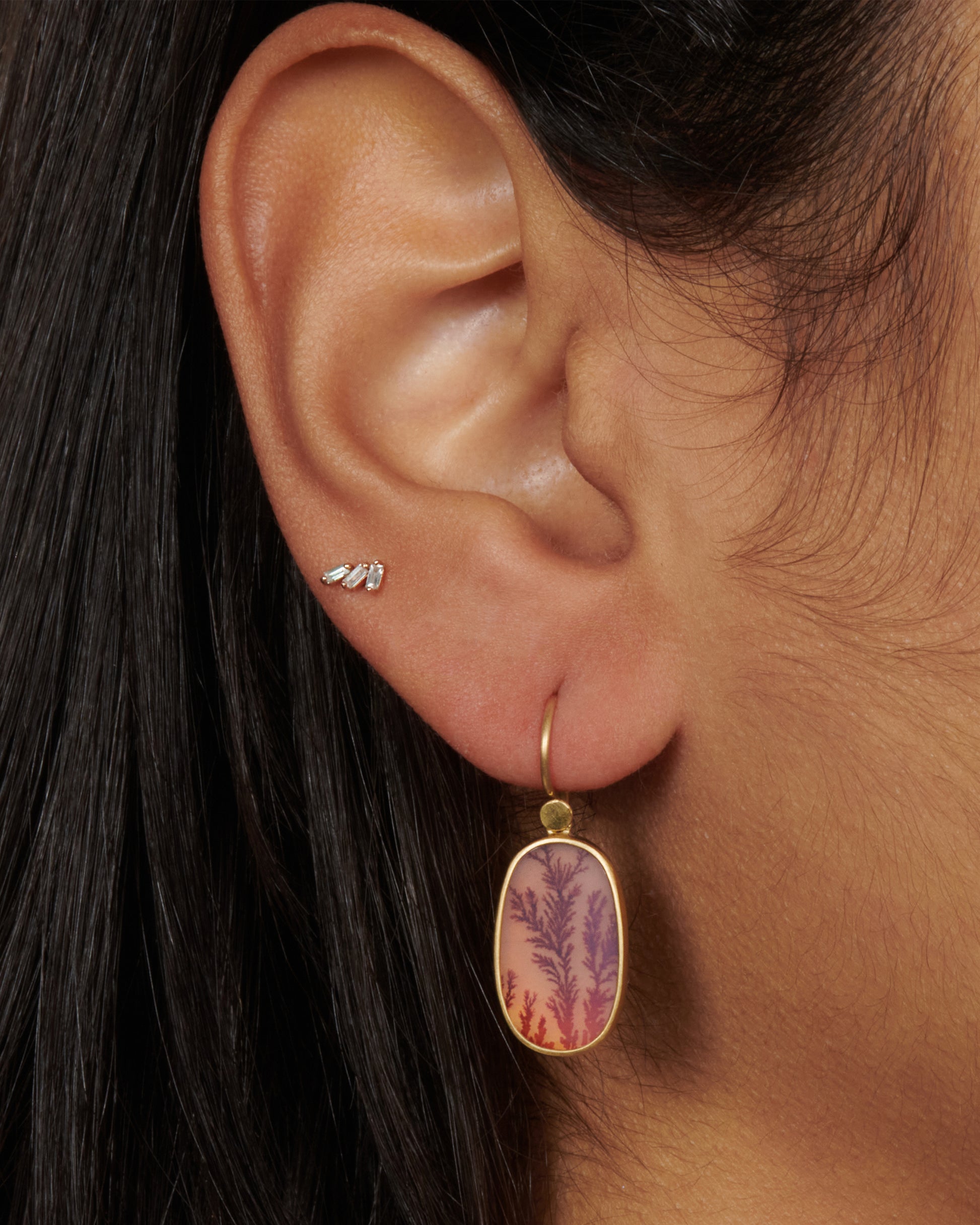A pair of 18k gold drops with oval fiery dendritic agate stones. The tree-like occlusions swim in rosy pink light, adding a warm, glowing effect.