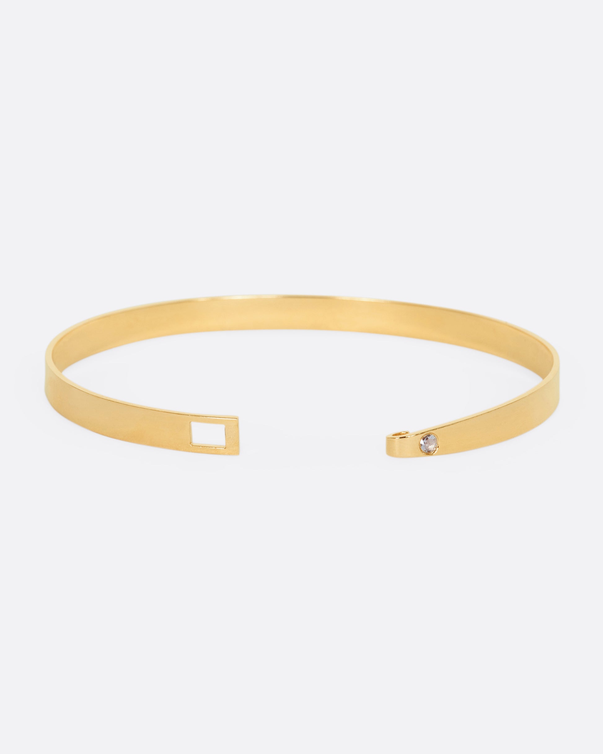 A yellow gold stripe bracelet with flush set rose cut diamond on the hook side. View opened.