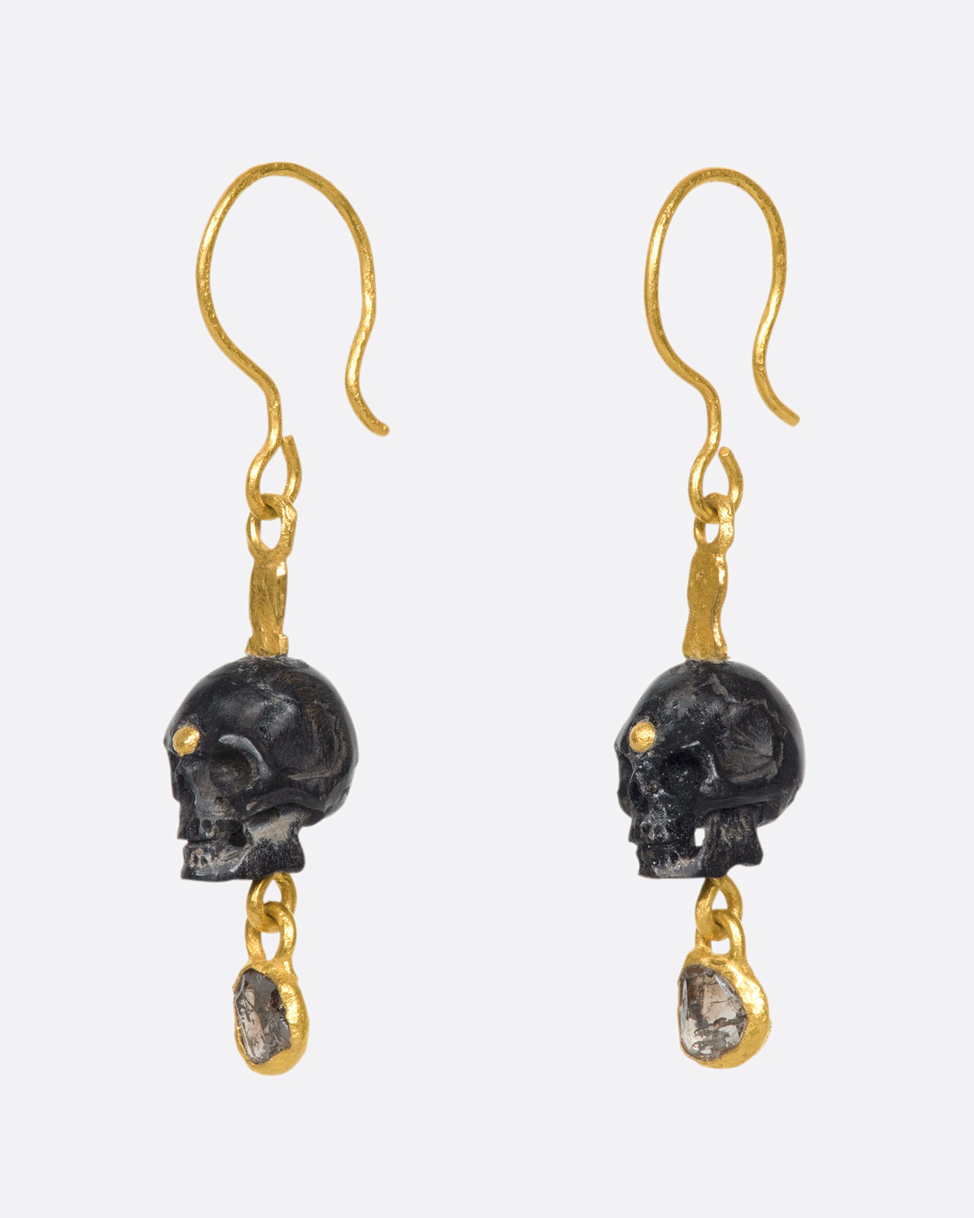 A pair of teeny, hand carved skulls with diamond dangles from Borneo.