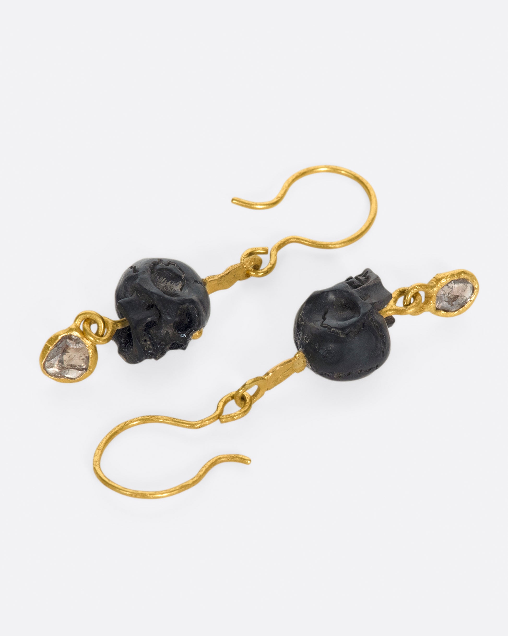 A pair of teeny, hand carved skulls with diamond dangles from Borneo.