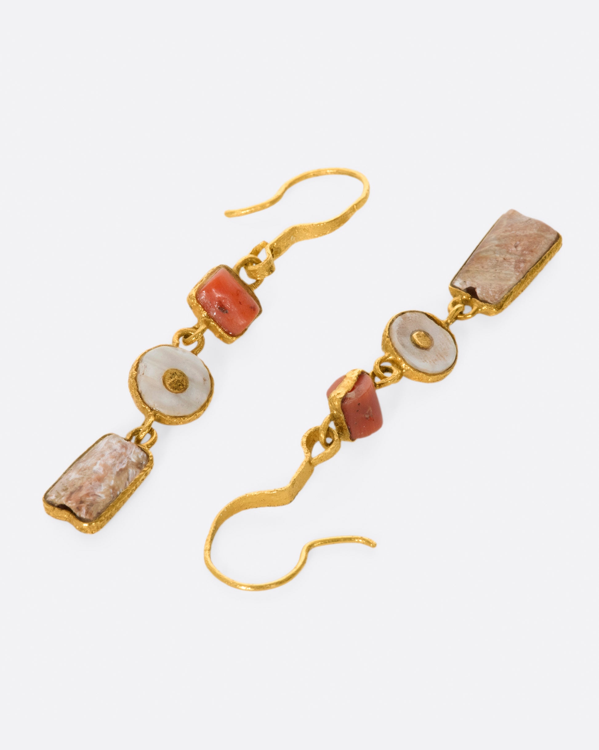 A pair of high karat gold triple drop earrings with coral and clay fragments