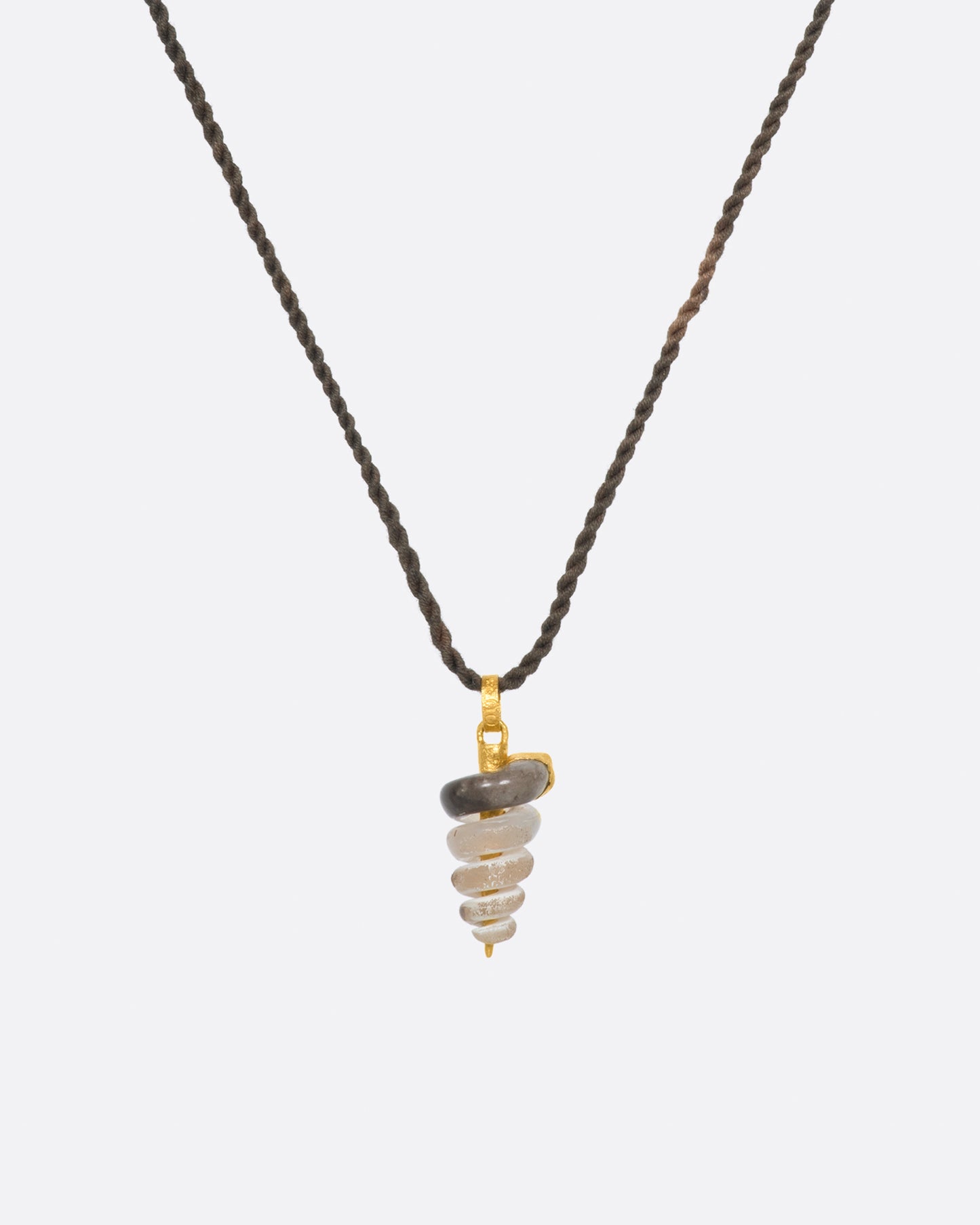 A fossilized snail pendant with gold winding its way down the inside