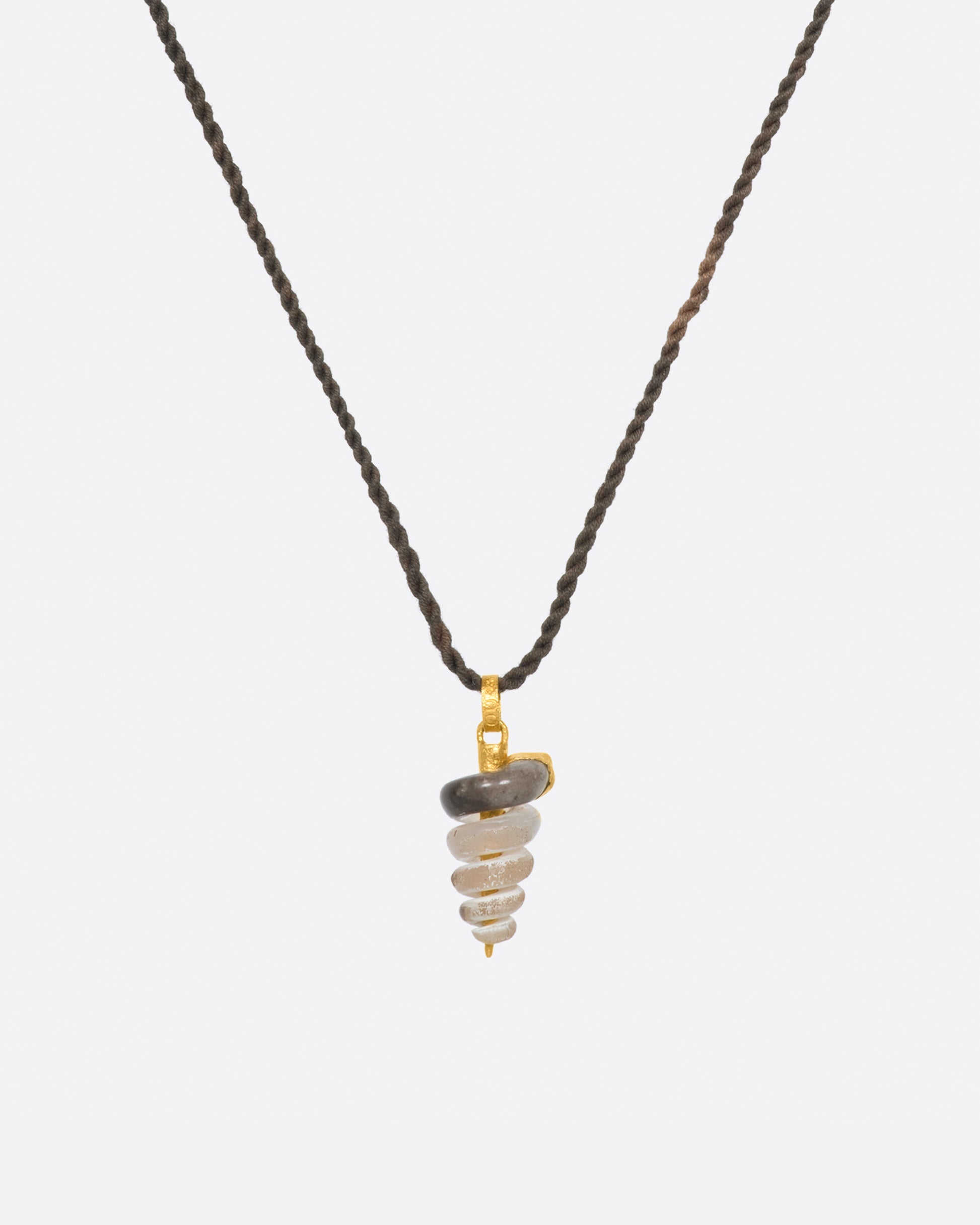 A fossilized snail pendant with gold winding its way down the inside