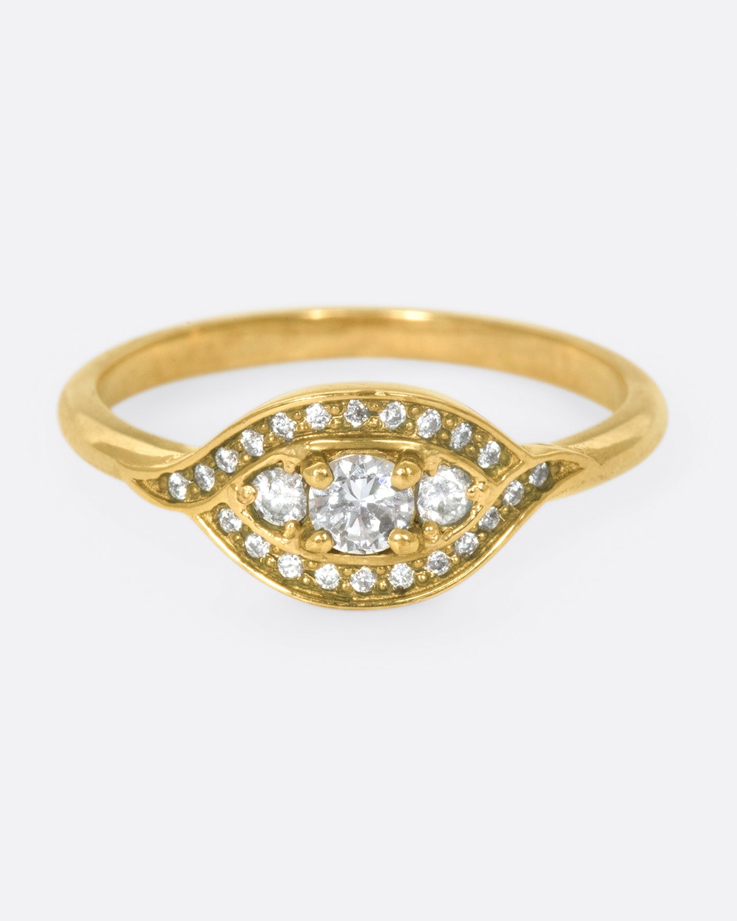 Two waves of pavé diamonds surround three rose cut white diamonds on this low profile ring