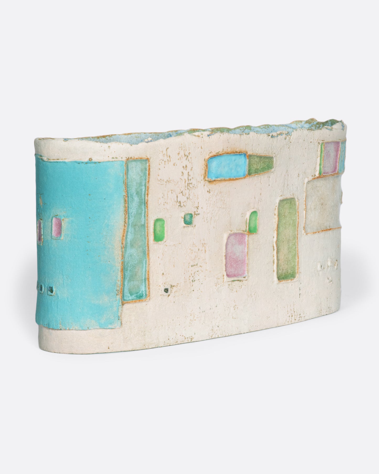 A ceramic vessel meticulously handmade with many layers of glaze atop stoneware clay. The rich, varied texture becomes a beautiful canvas for a dreamy slice of a sun-drenched town in Greece.