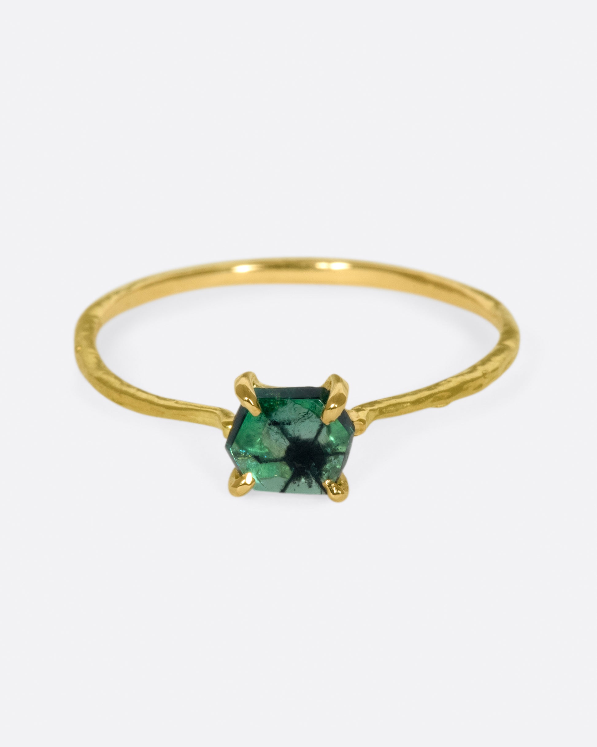 The hexagonal cut of complements the spoke-like pattern on the interior of this emerald.
