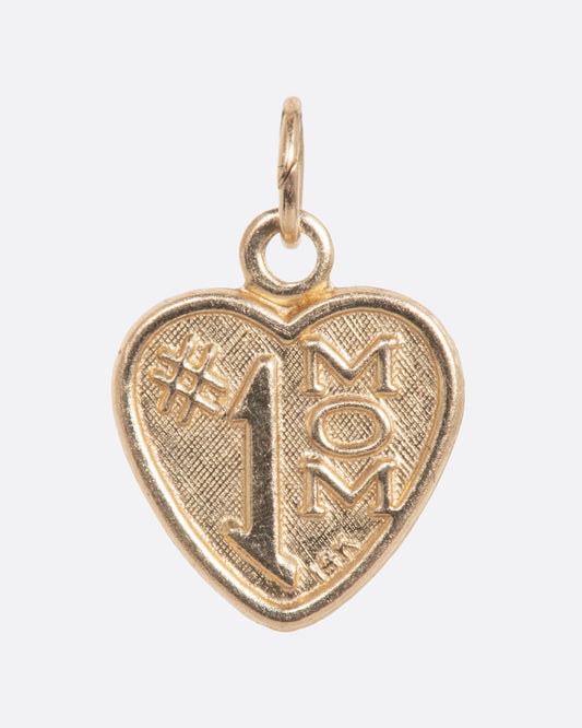 Gold heart shaped charm that reads '#1 Mom'. View from the front.