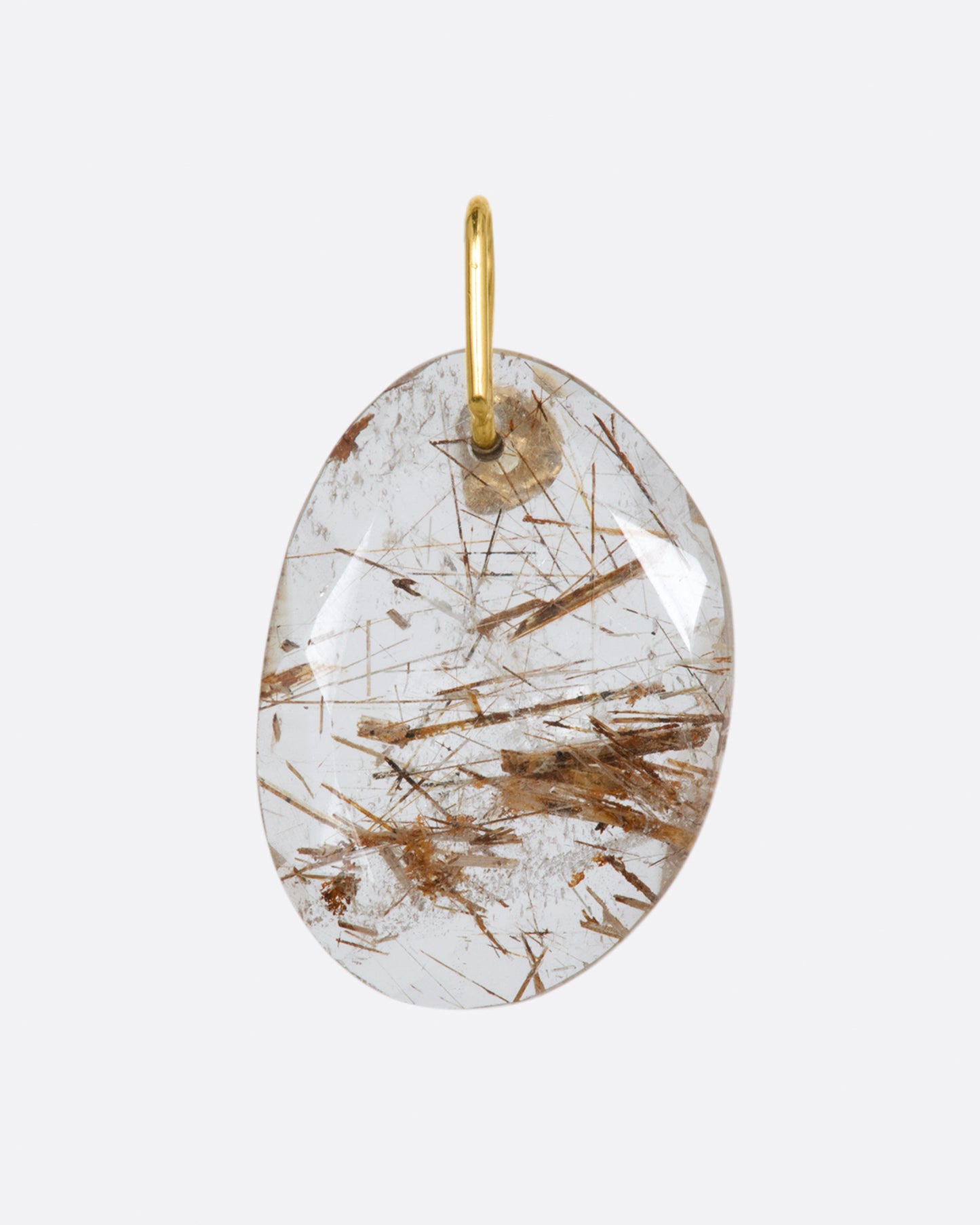 A yellow gold charm featuring a slice of rutilated quartz, with a yellow sapphire at its center. Shown from the back.