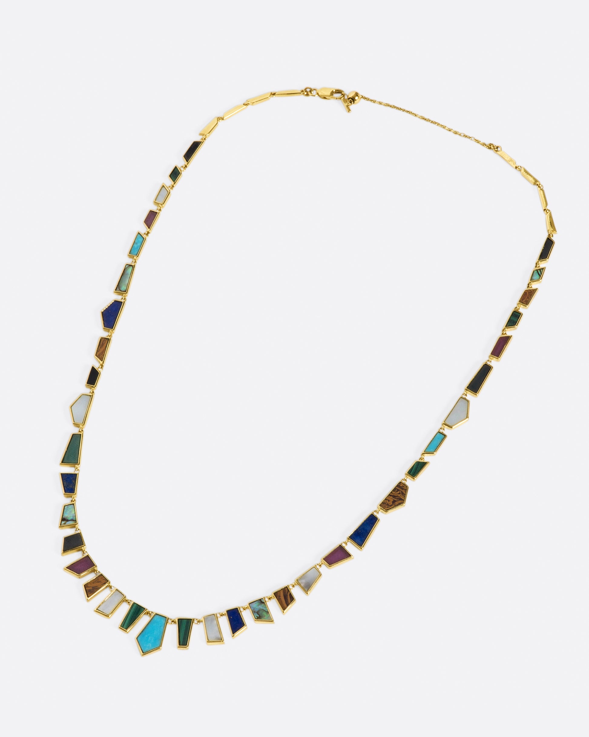 An exceptional array of geometric, hand-cut stones intricately laid in 9k gold. Look closely and, you'll notice the stones are symmetrically cut, while each color is different.