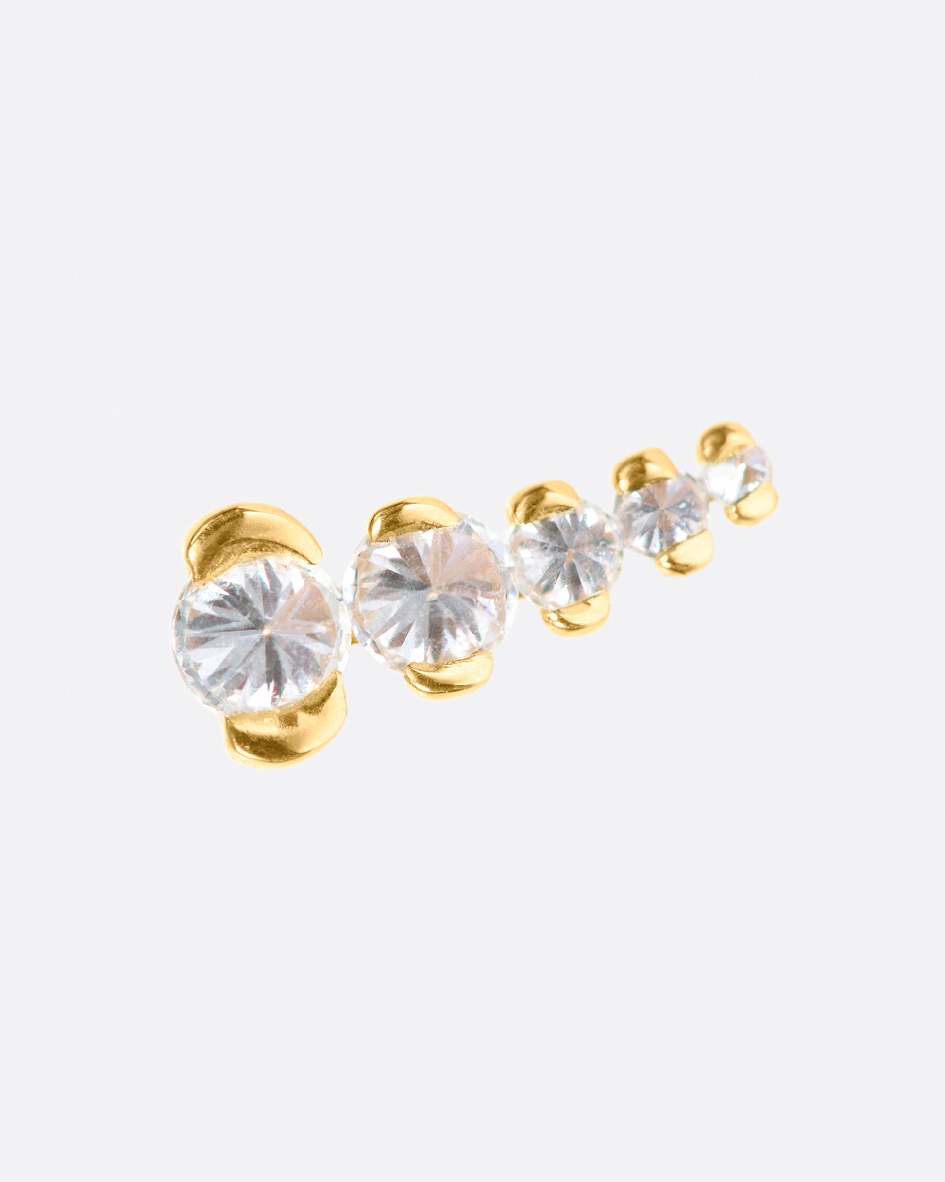 A gold stud with five inverted diamonds arranged in a slight curve.