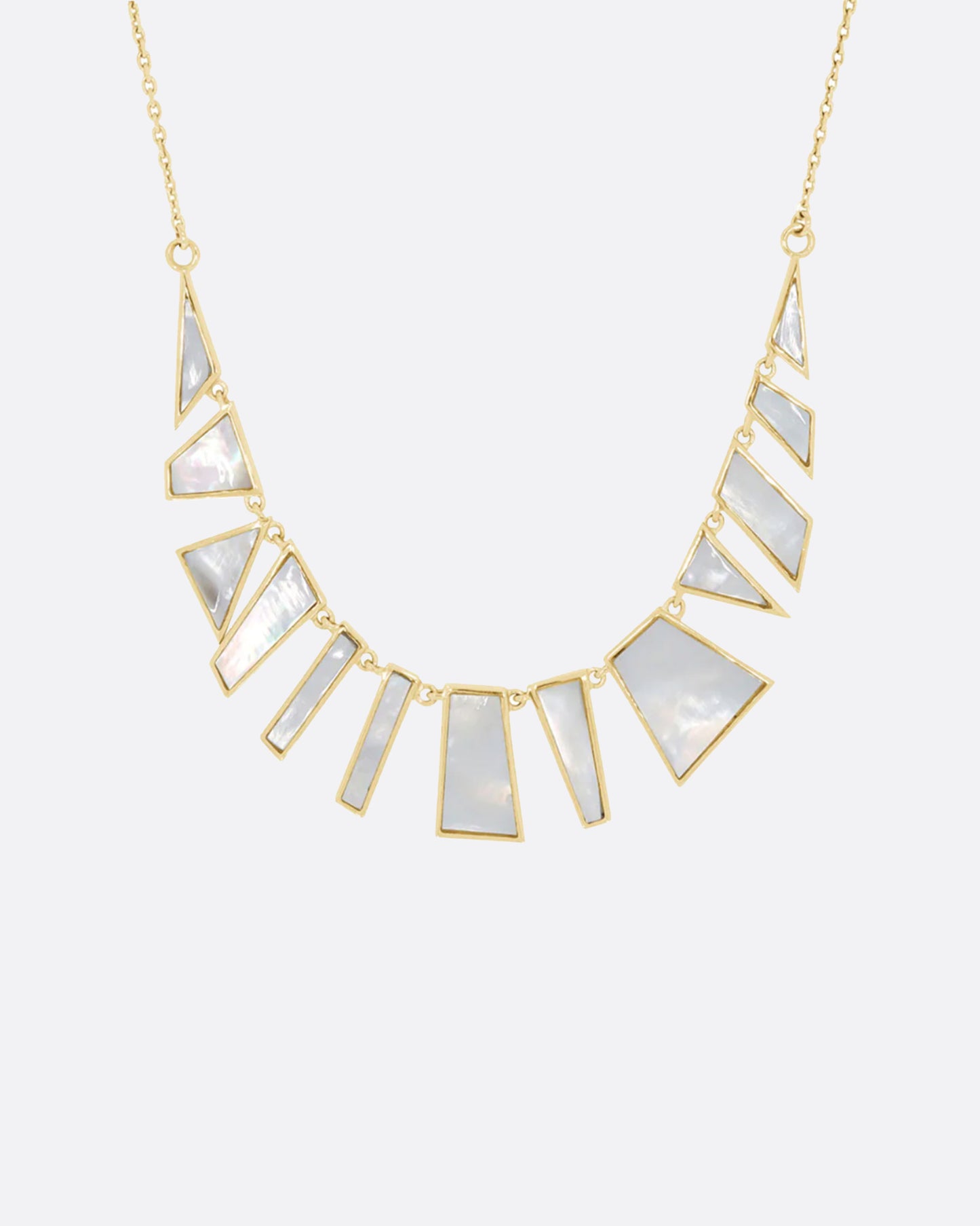 Inspired by a pair of earrings found while on vacation, this necklace reflects light with its iridescent white sections.