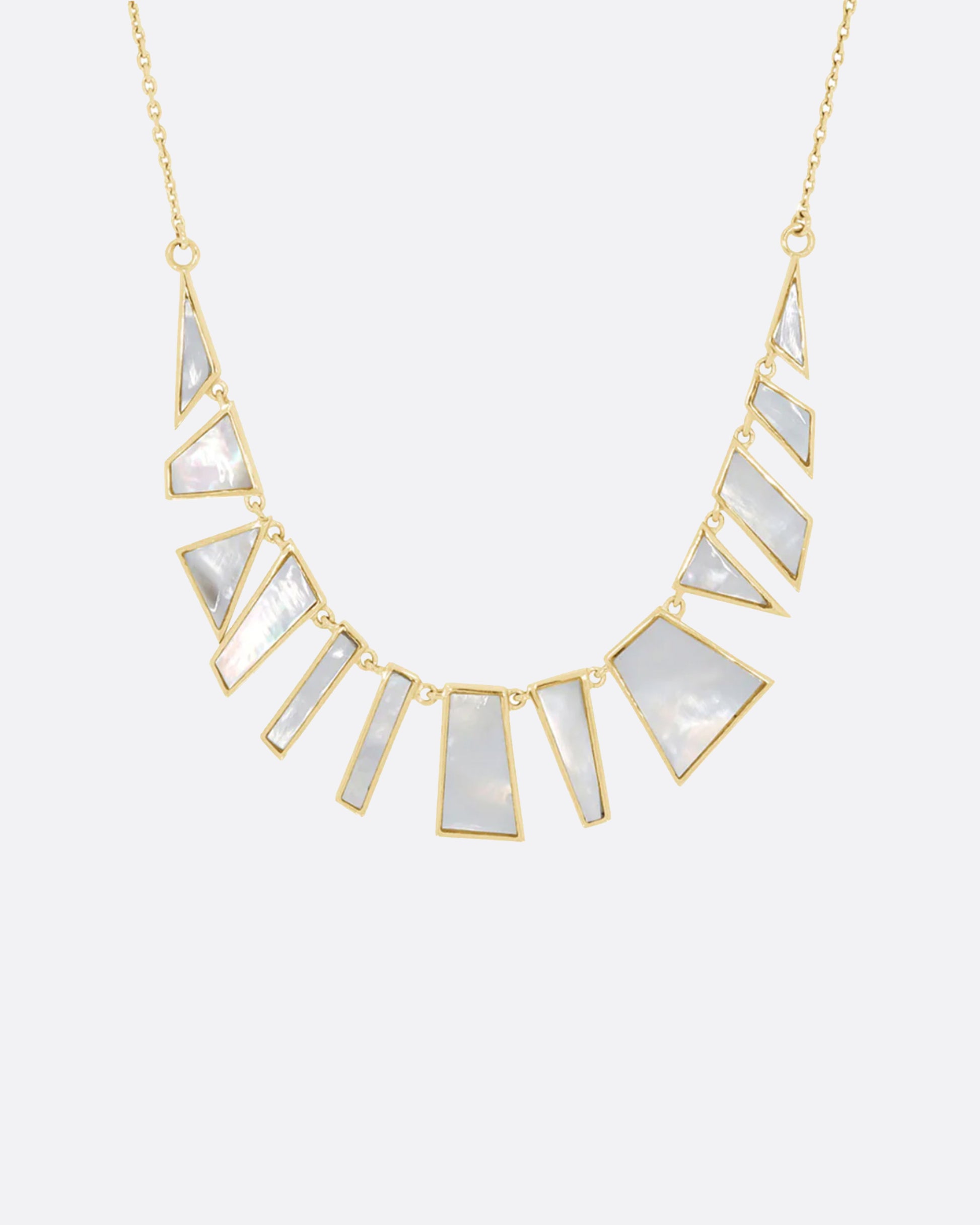 Inspired by a pair of earrings found while on vacation, this necklace reflects light with its iridescent white sections.