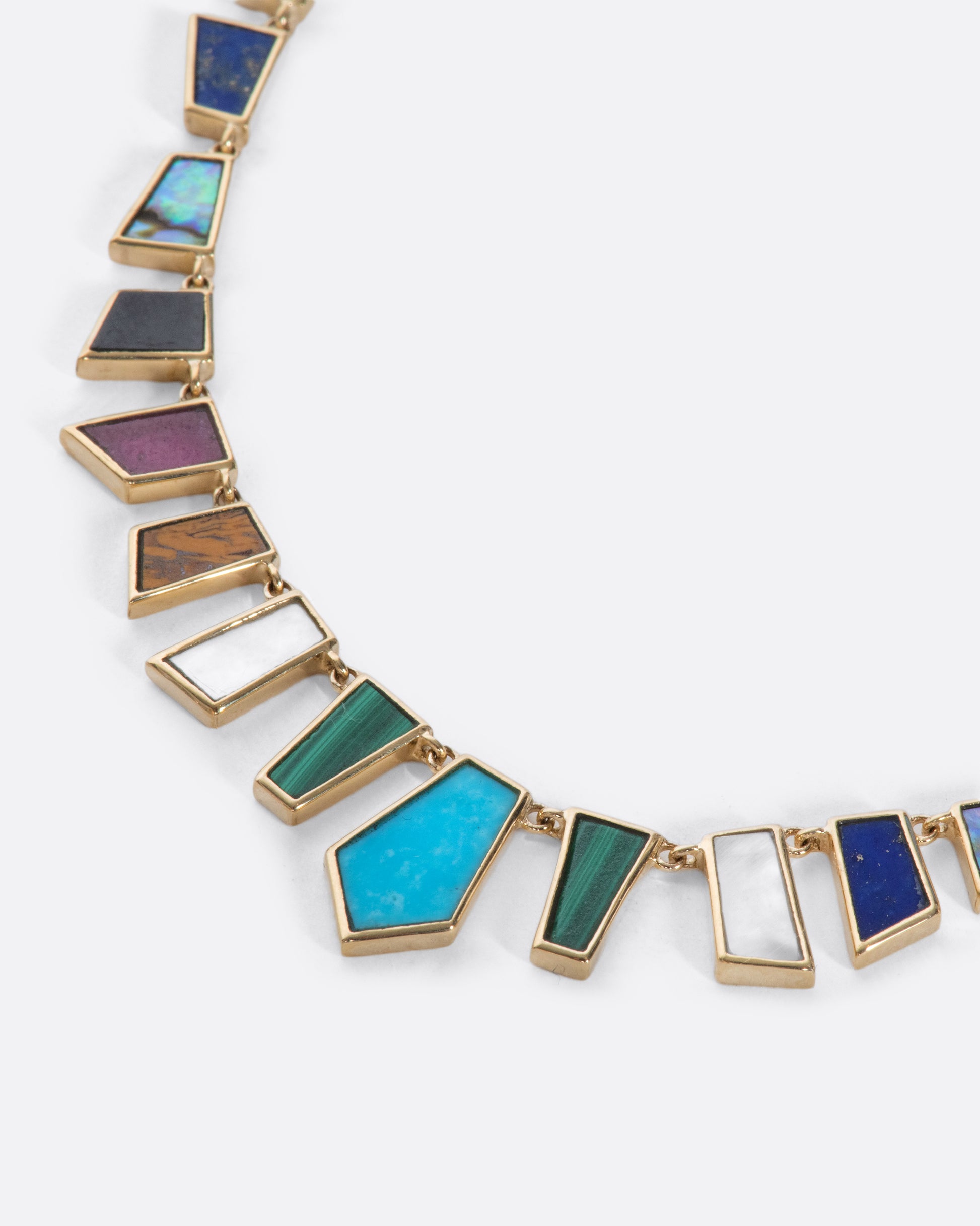 An exceptional array of geometric, hand-cut stones intricately laid in 9k gold. Look closely and, you'll notice the stones are symmetrically cut, while each color is different.