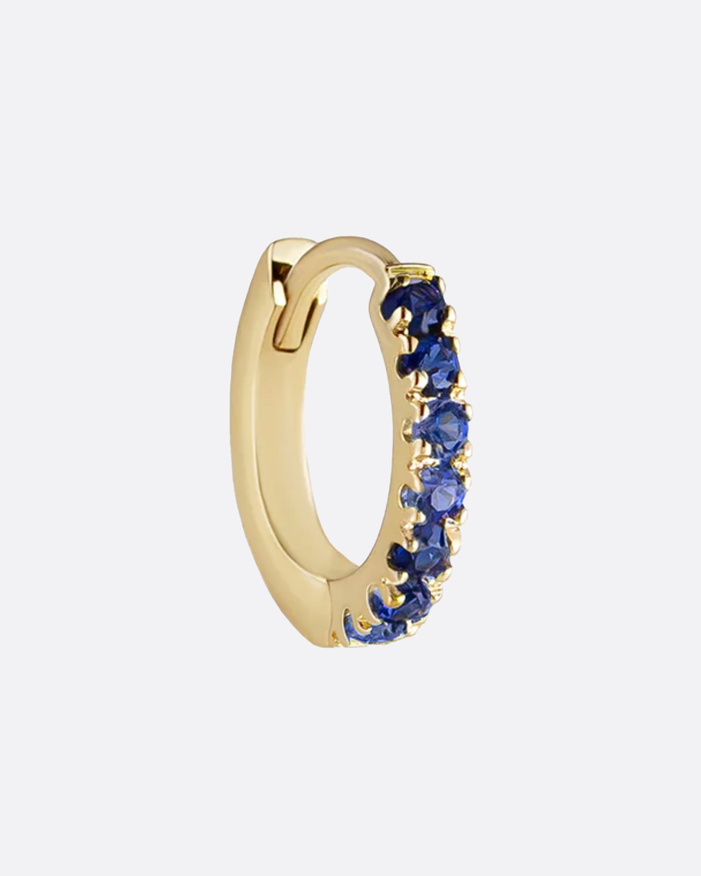 A small, hinged hoop lined with deep blue sapphires.