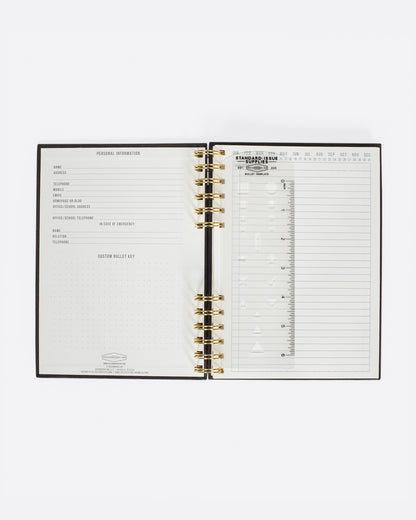 Black spiral notebook, open to the first pages