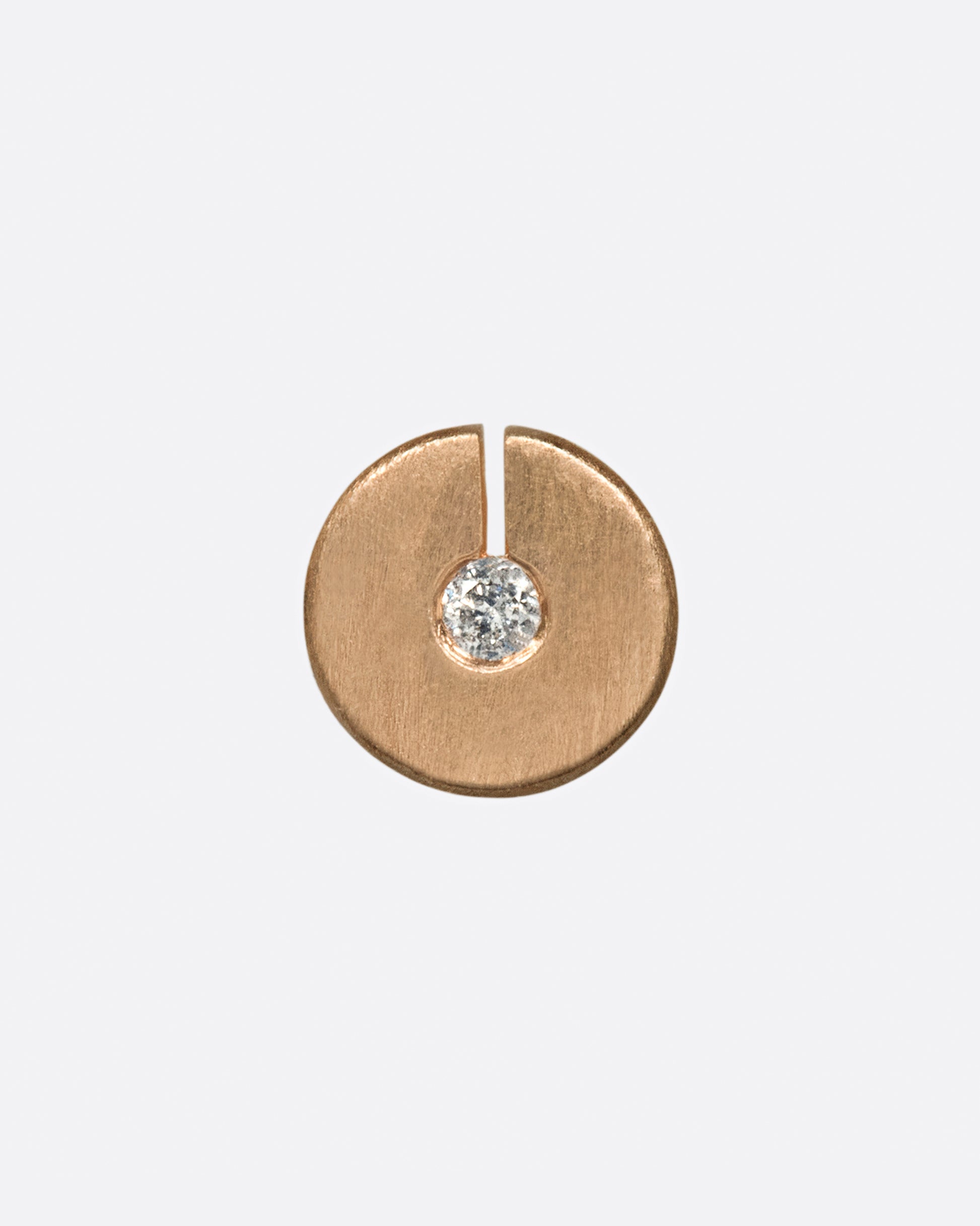 This disc stud has a diamond at its center, made even more dazzling by the break in the circle that allows light in.
