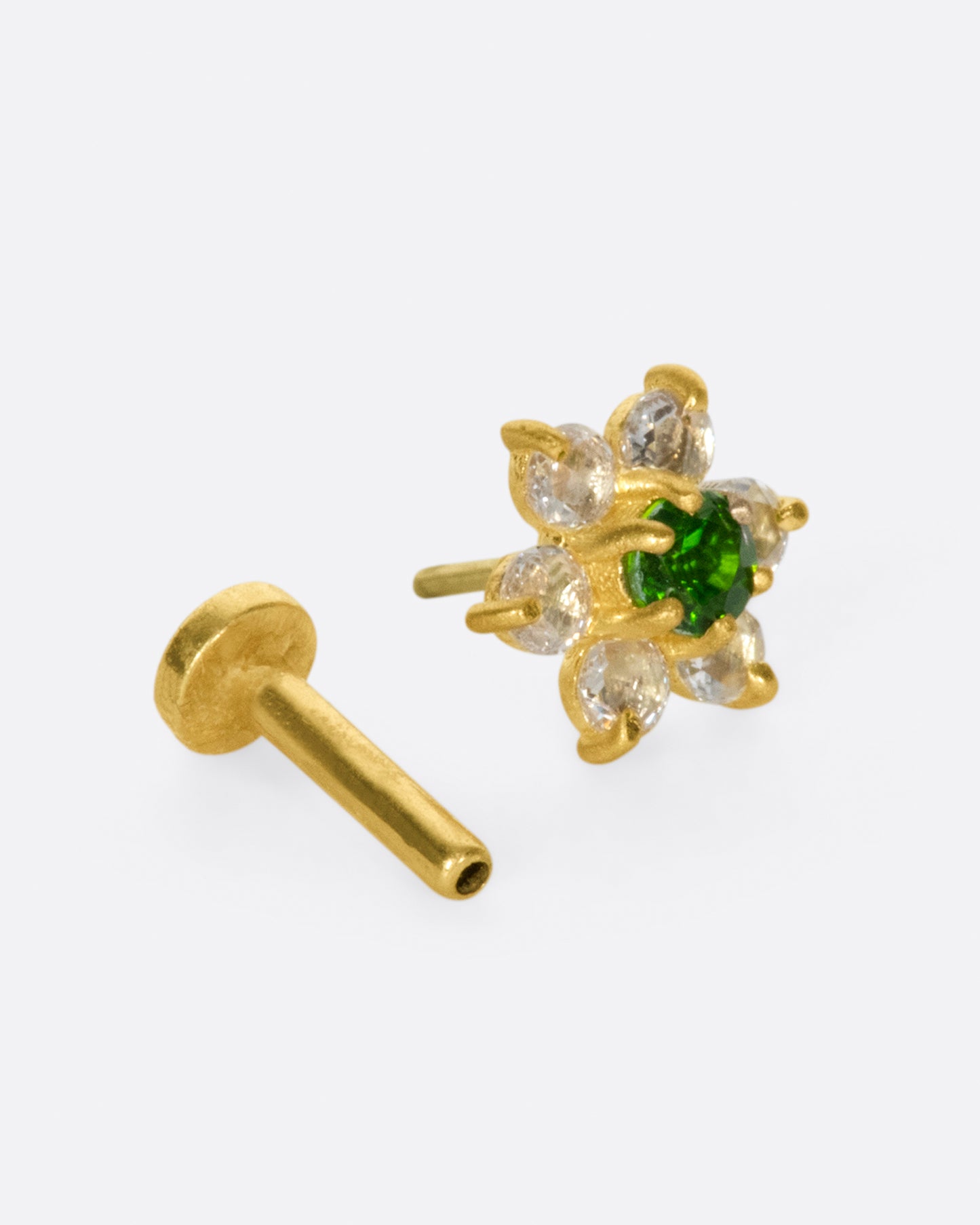 A yellow gold threadless earring front made from 6 white diamond and one green chrome diopside in the shape of a flower. Shown with a backing.