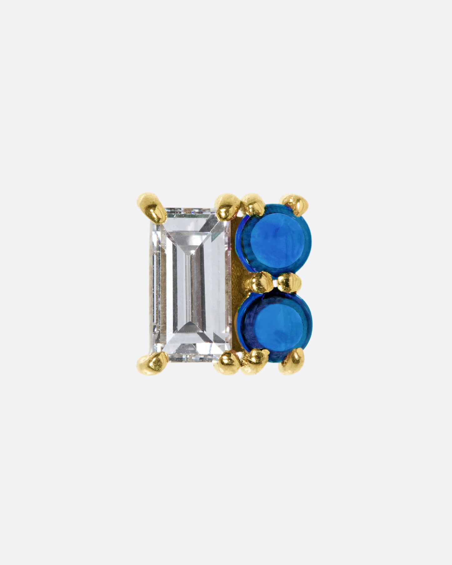 Two deep blue sapphire cabochons form half of this square earring; a baguette diamond the other half.