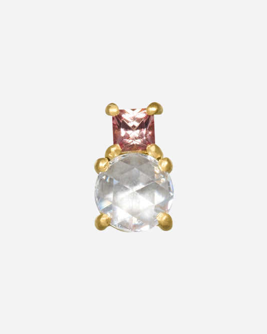 An uncommon combination; a rose cut diamond with a peachy pink princess cut sapphire.