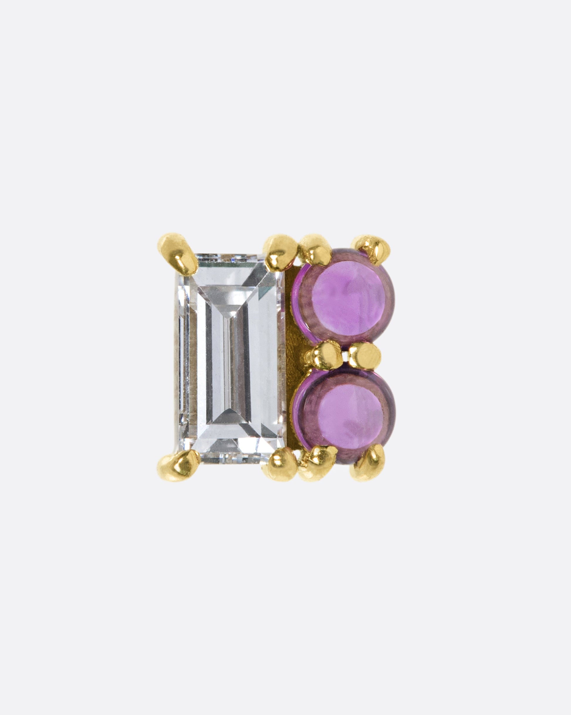 A square earring made up of a diamond baguette and two ruby cabochons; a combination of color, shape, and shine.