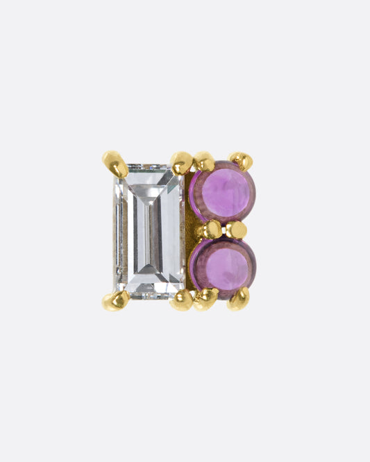 A square earring made up of a diamond baguette and two ruby cabochons; a combination of color, shape, and shine.