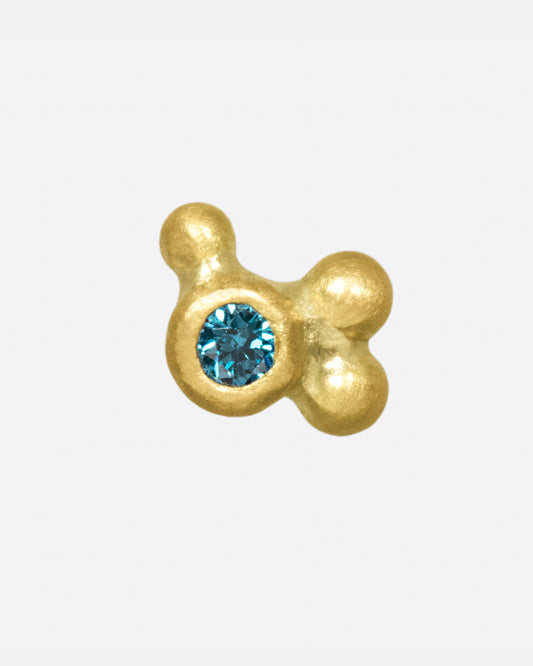 A bezel set teal blue diamond with three asymmetrical, matte gold beads.