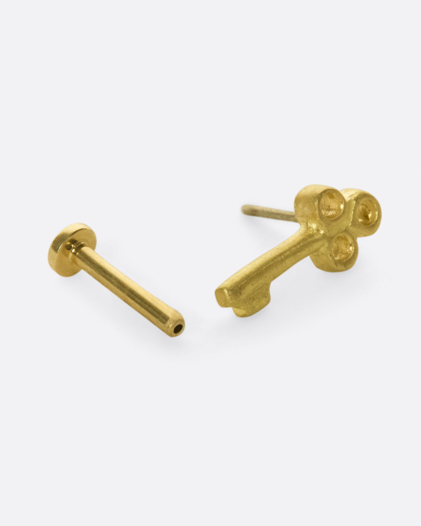 A tiny, matte gold key to adorn your ear.