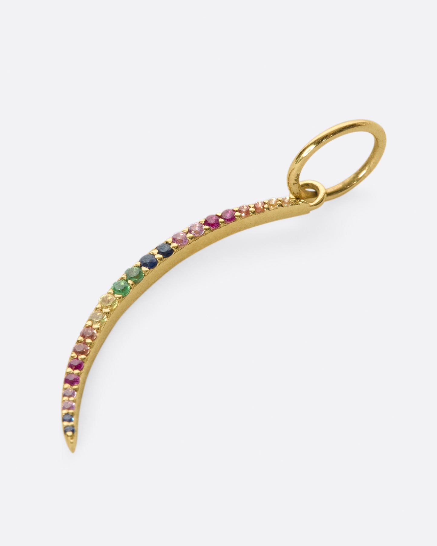 A curved, elongated gold sliver lined with rainbow sapphires. The length of this dangle makes it great for layering.