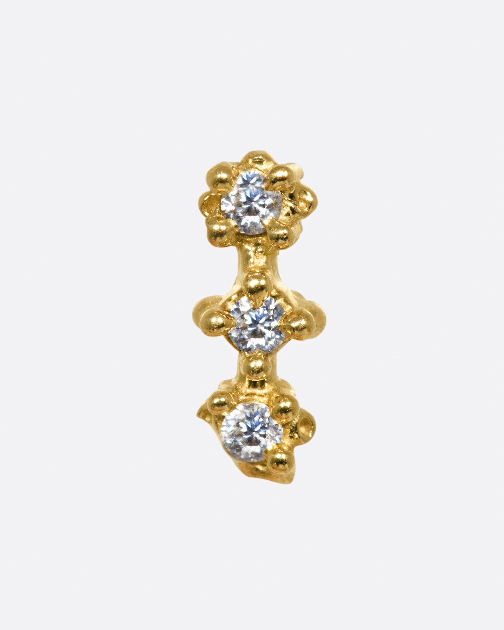 An organically shaped and textured diamond bar earring.