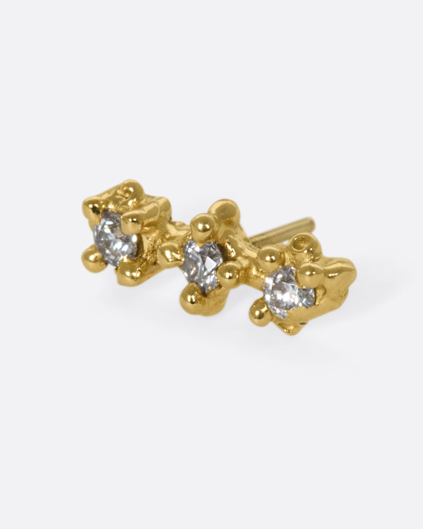 An organically shaped and textured diamond bar earring.