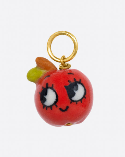 A handmade porcelain 3D apple charm with a smiling face and a yellow gold bail.