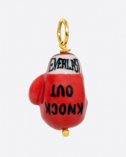 A handmade porcelain red Everlasting boxing glove charm with the words "Knock out" written on it, with a yellow gold bail.