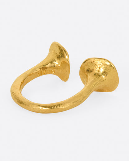 A high karat gold open ring with a large organic shaped disc on each end with a rosey pink tourmaline at its center. Shown from the side.