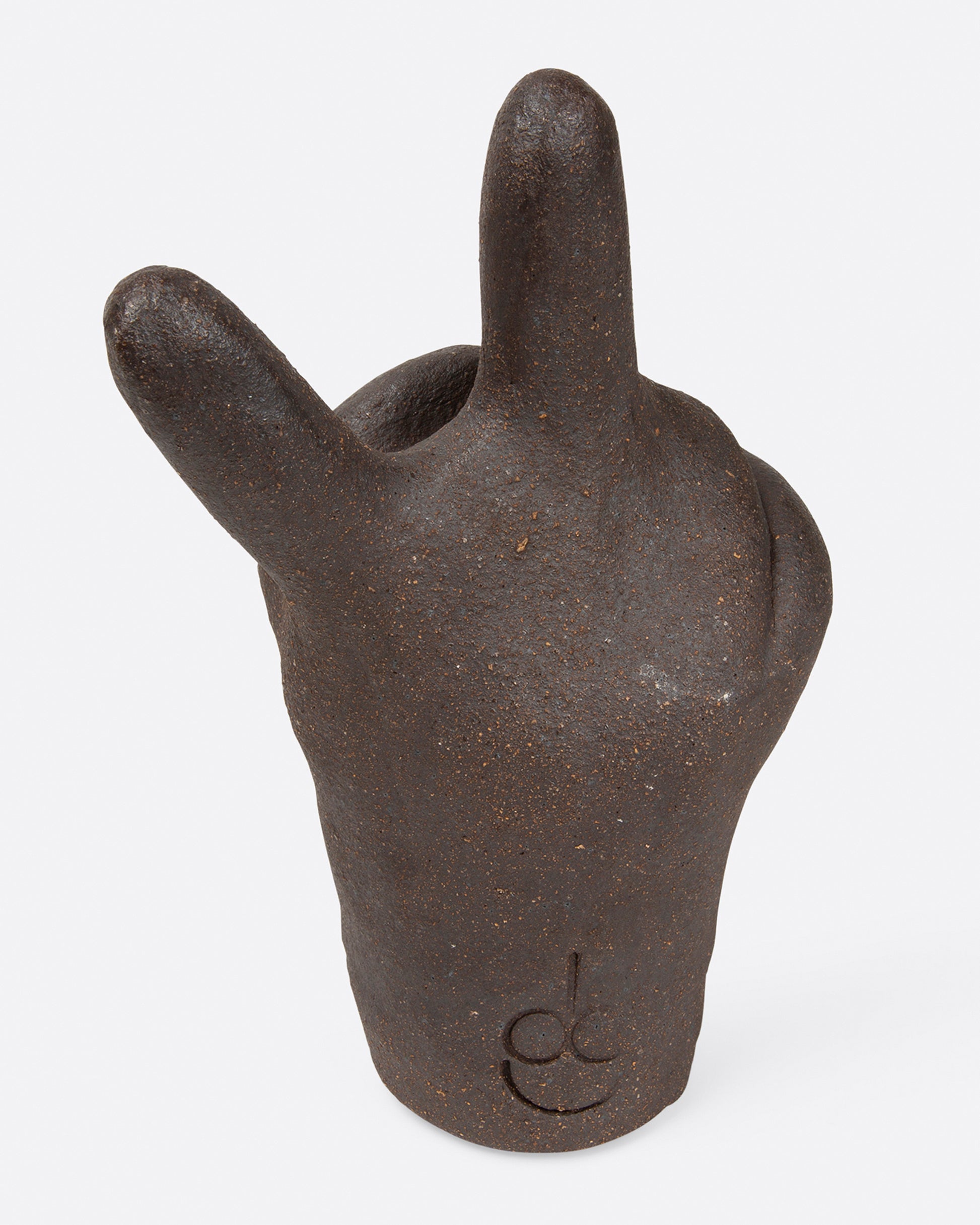 A large, dark brown peace hand sculpture, shown from the back.