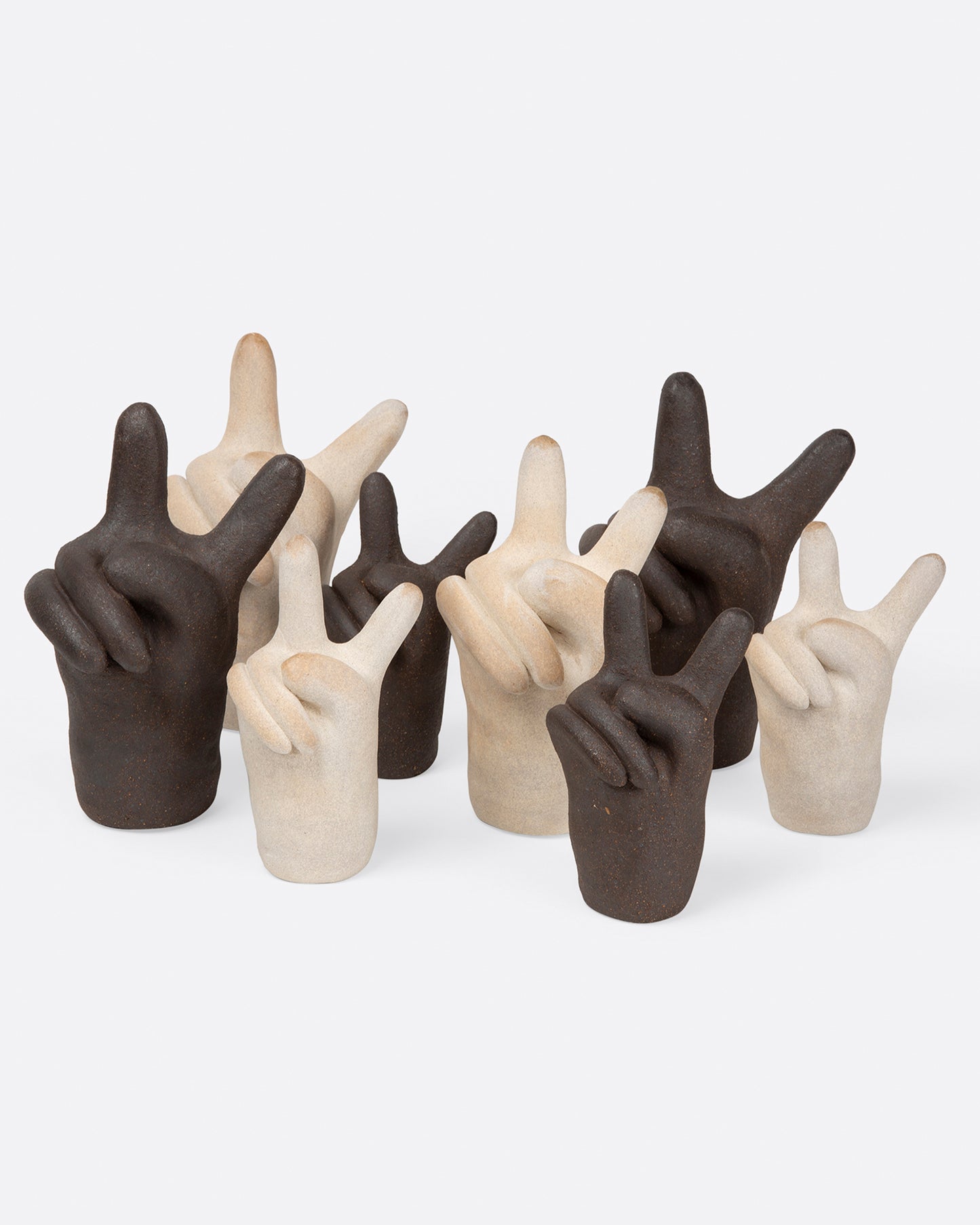 A group of off-white and dark brown peace hand sculptures, shown from the front.
