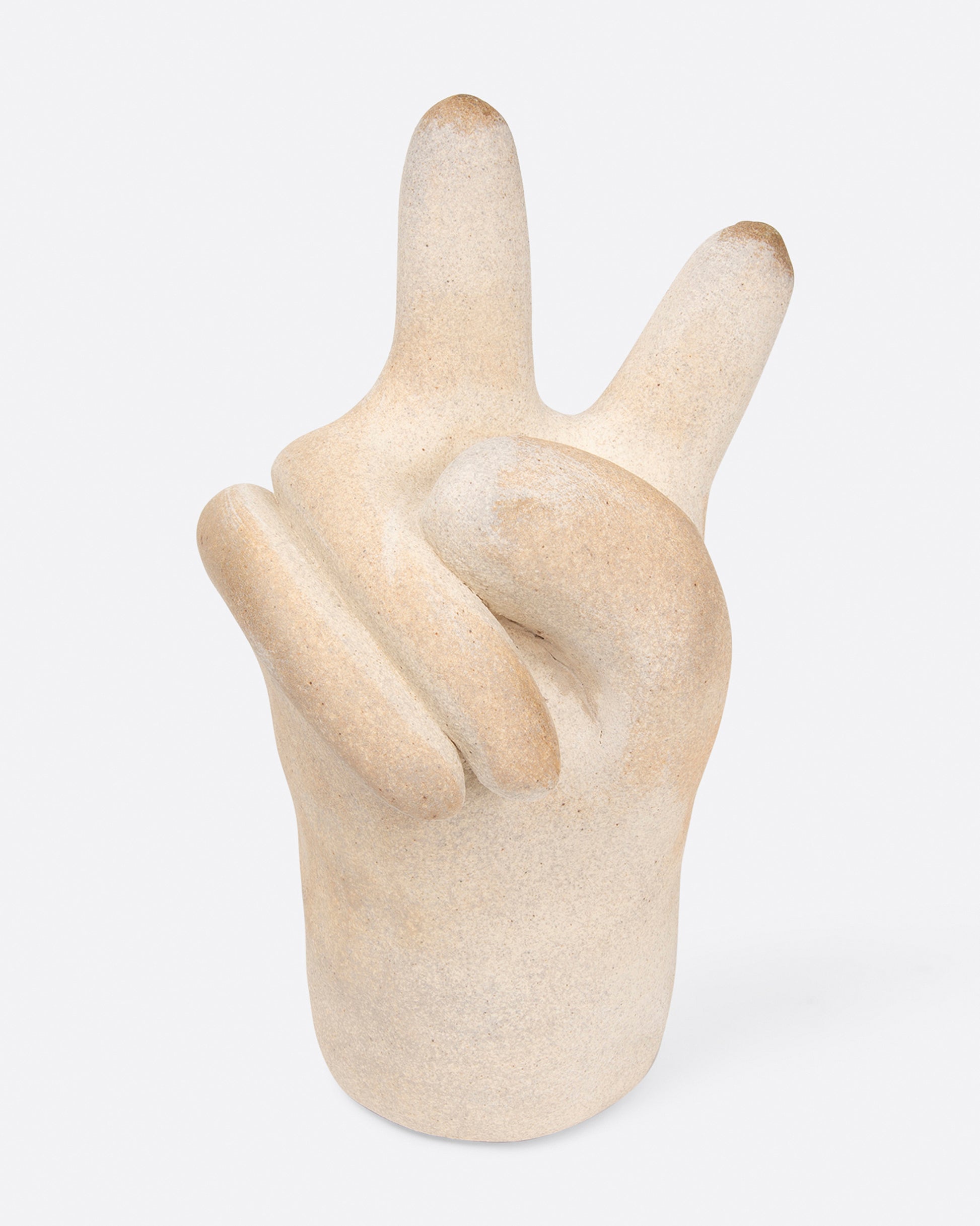 A large, off-white peace hand sculpture, shown from the front.