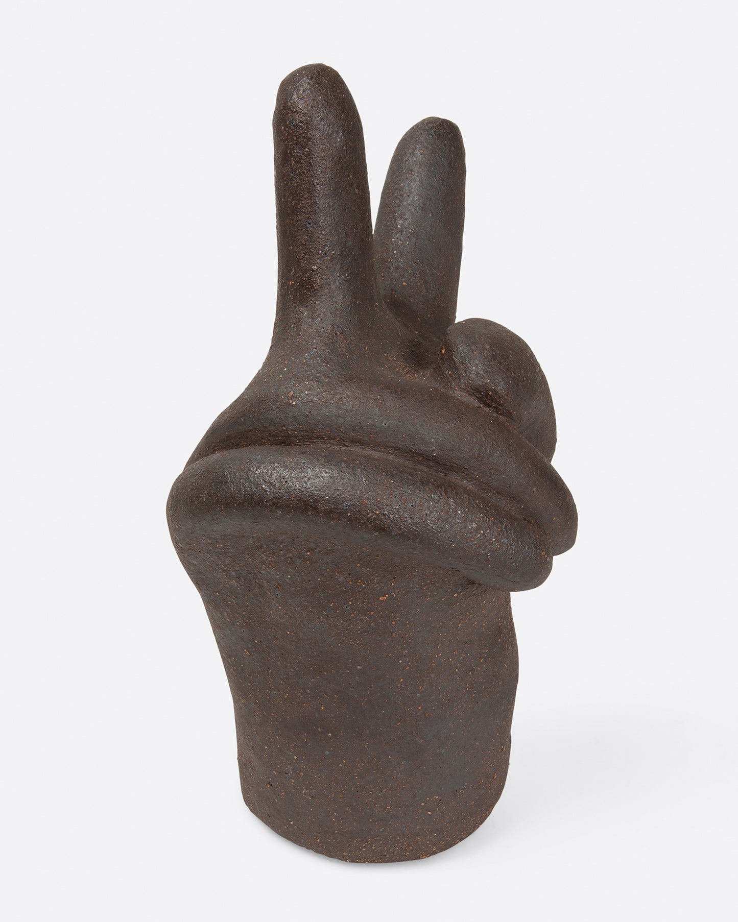 A large, dark brown peace hand sculpture, shown from the side.