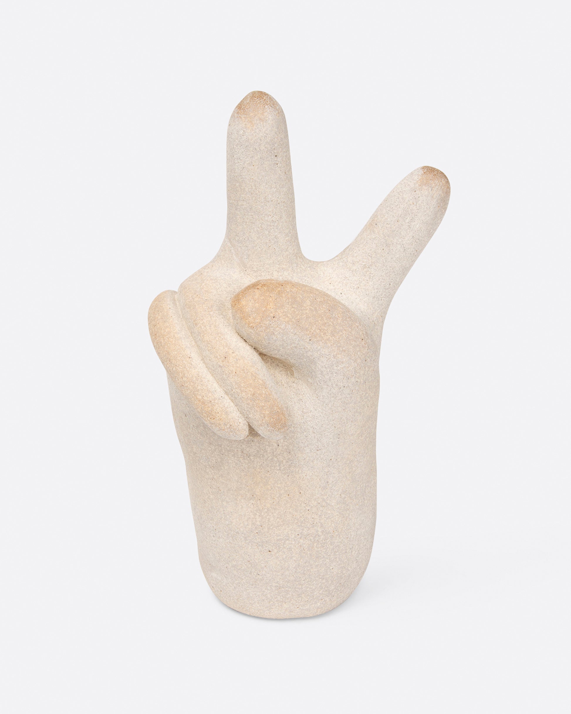A small, off-white peace hand sculpture, shown from the front.