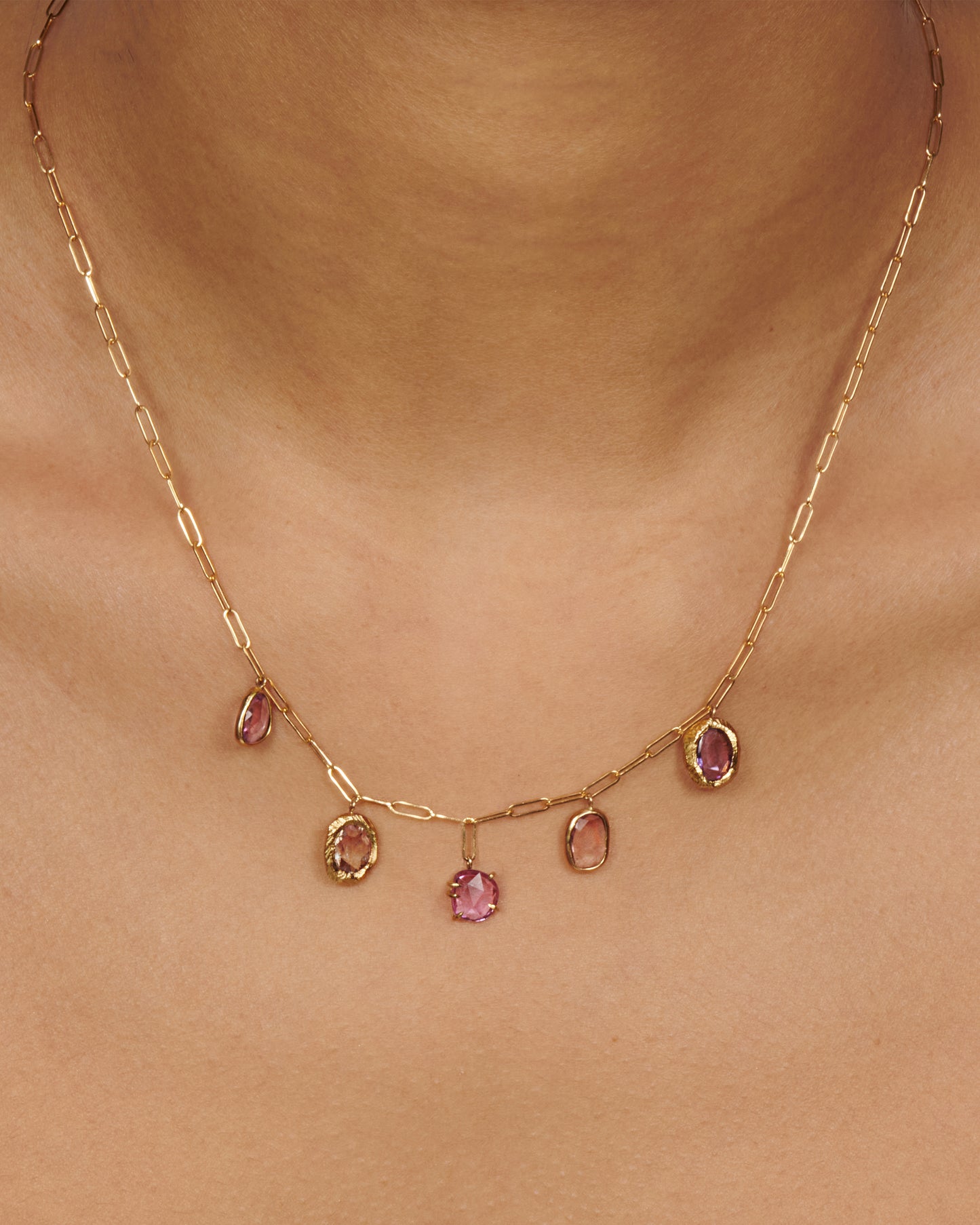 An oval link chain necklace with five rose cut sapphires, each in its own unique setting.