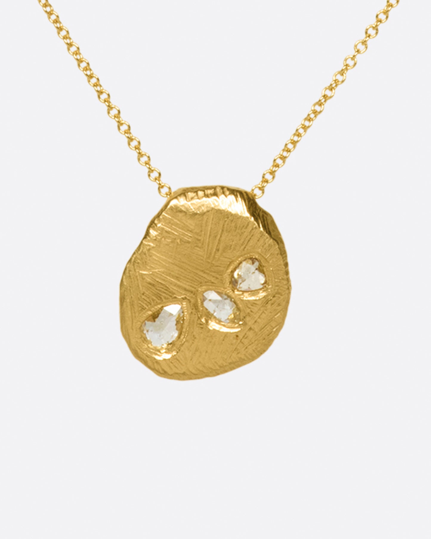 A heavy, hand carved, sliding gold pendant with three rose cut diamonds on a cable chain.