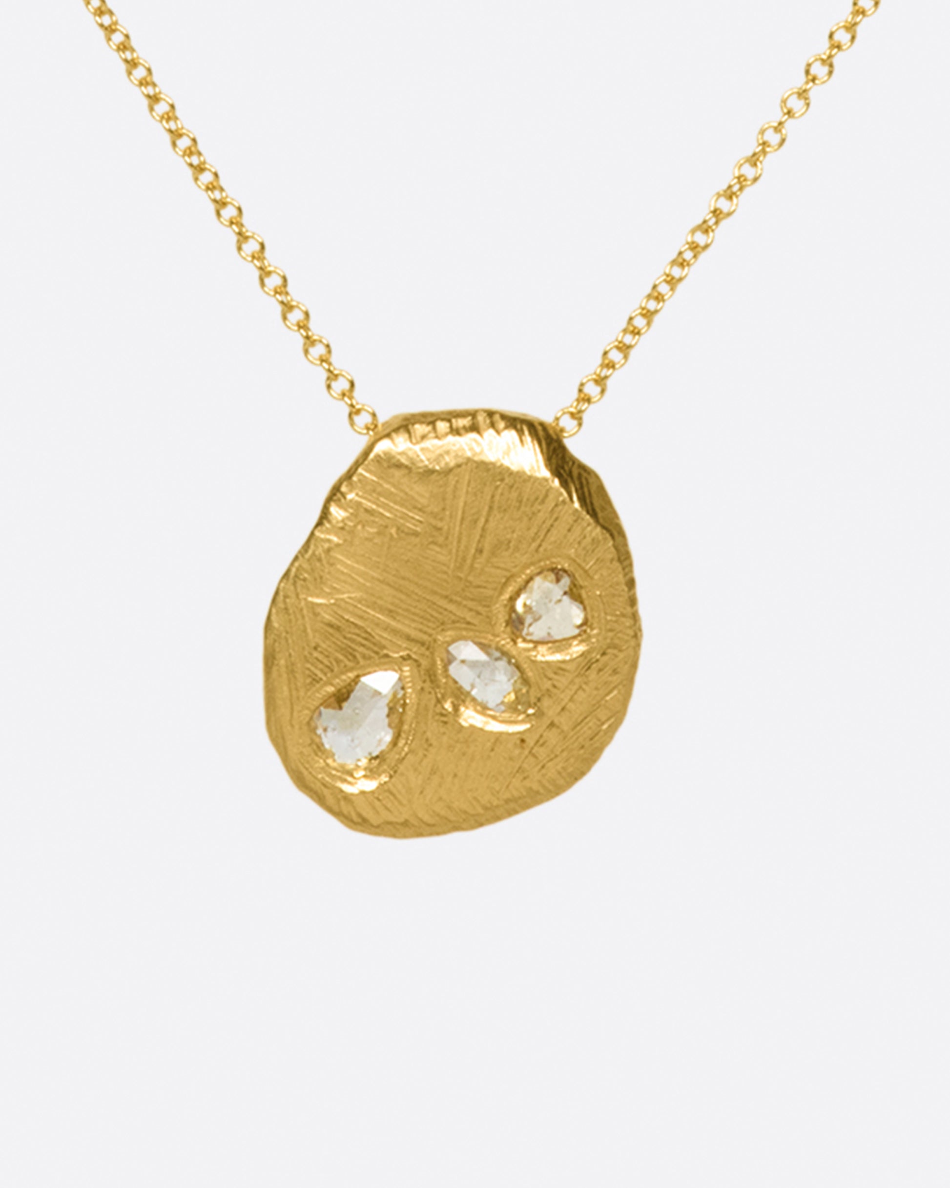 A heavy, hand carved, sliding gold pendant with three rose cut diamonds on a cable chain.