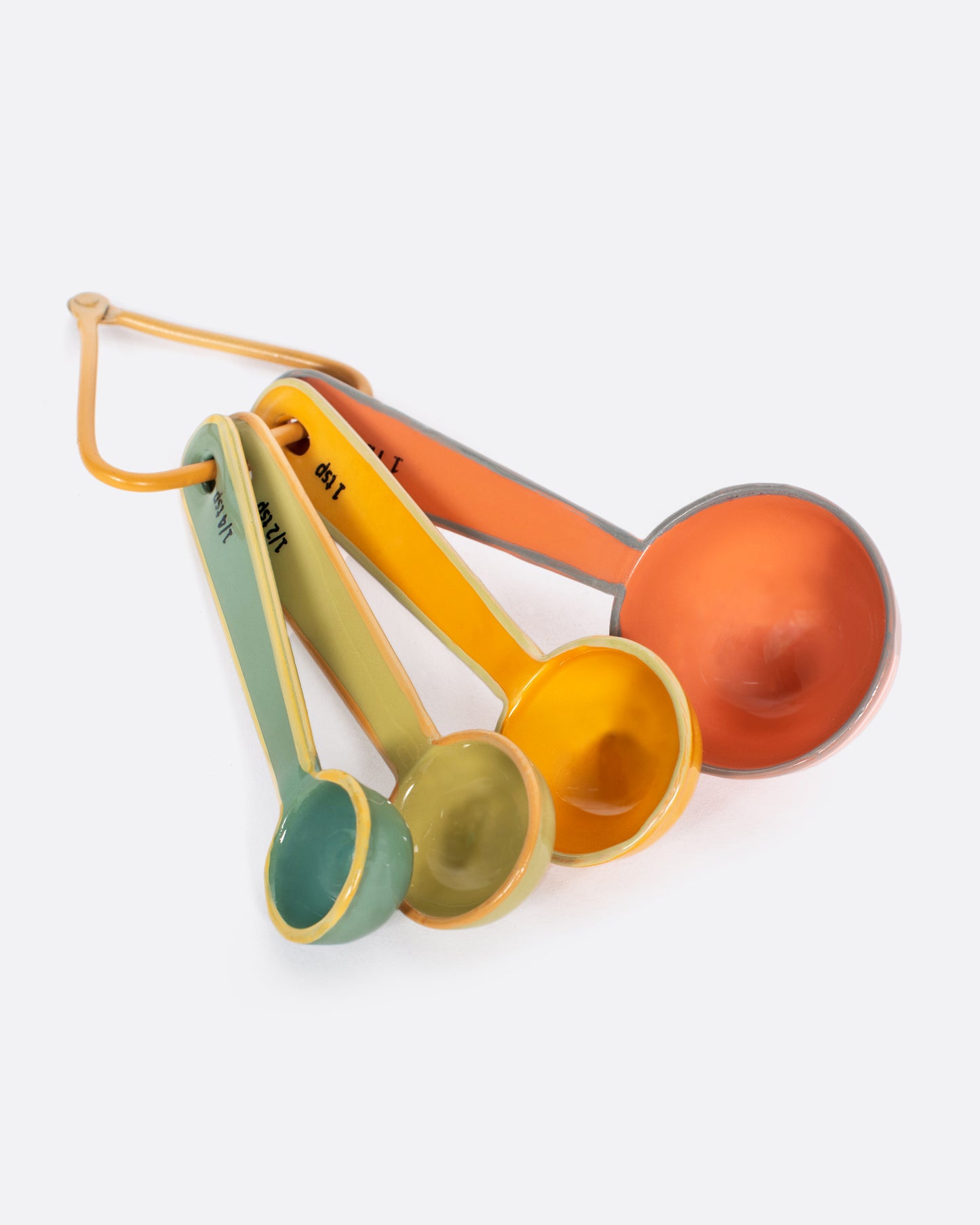 A set of four measuring spoons, each a different color, on a triangular carabiner.