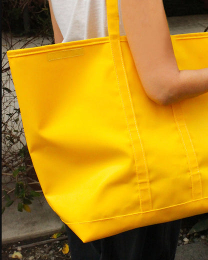 Yellow canvas tote bag, carried on a shoulder