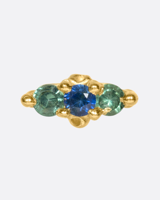 A 14k gold stud adorned with blue and green sapphires