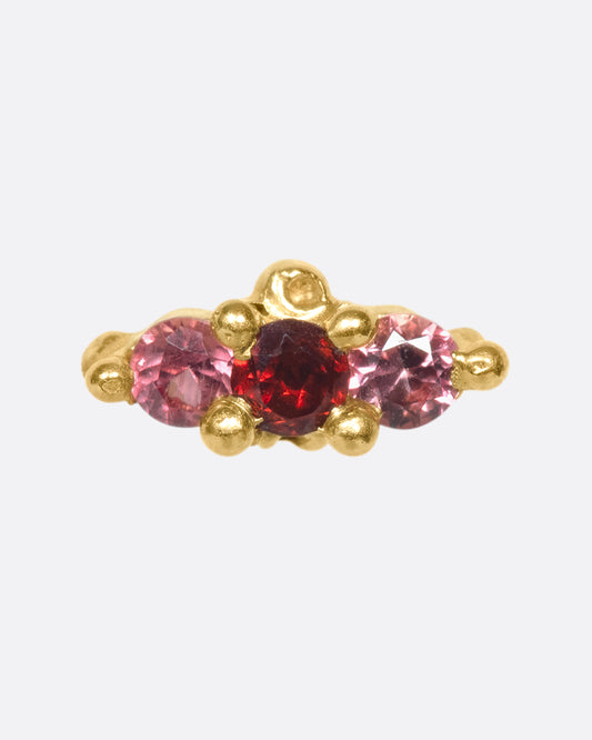 A 14k gold stud adorned with red and orange sapphires