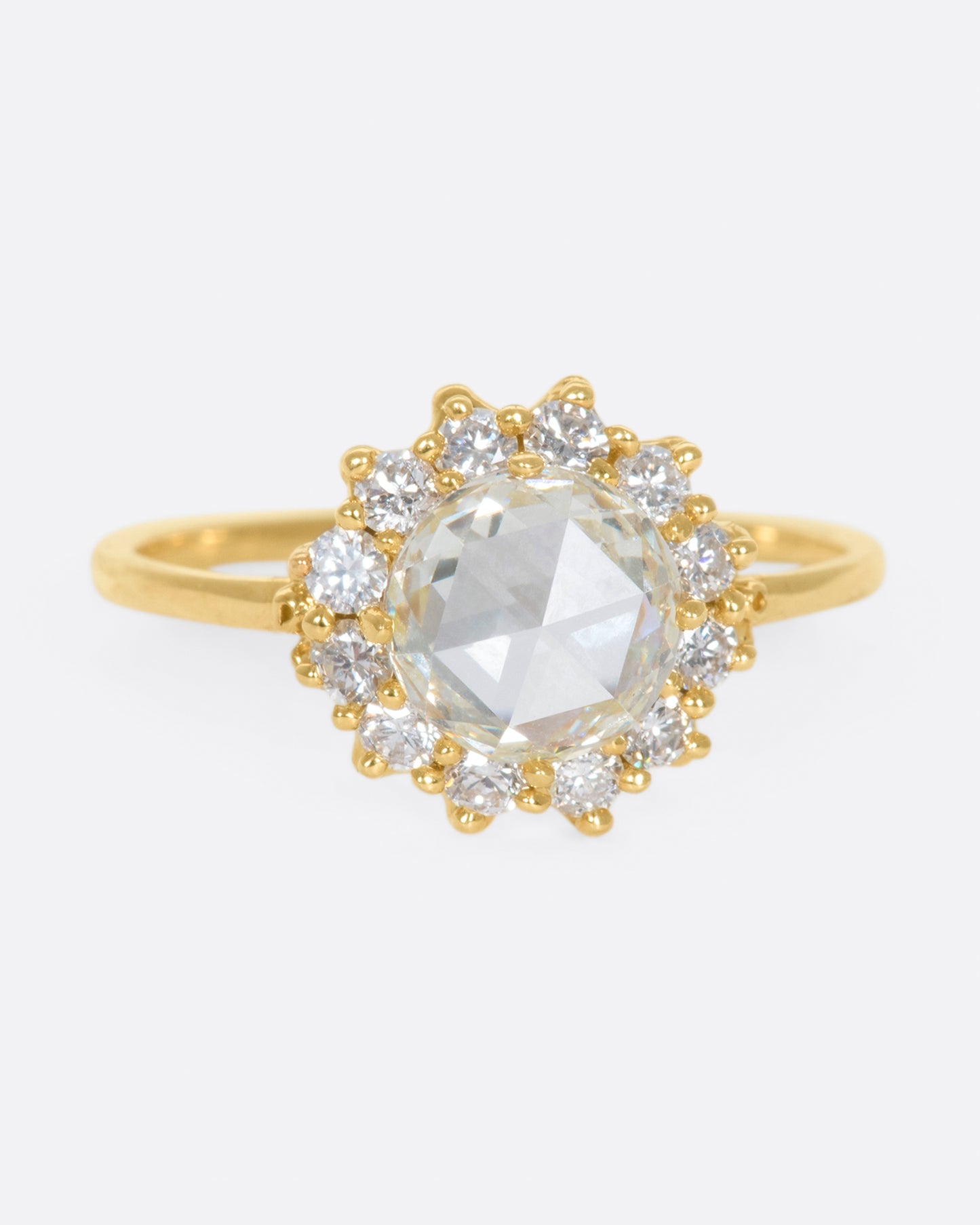 This light champagne, rose cut diamond is surrounded by a diamond halo, giving it the illusion of a shining sun.