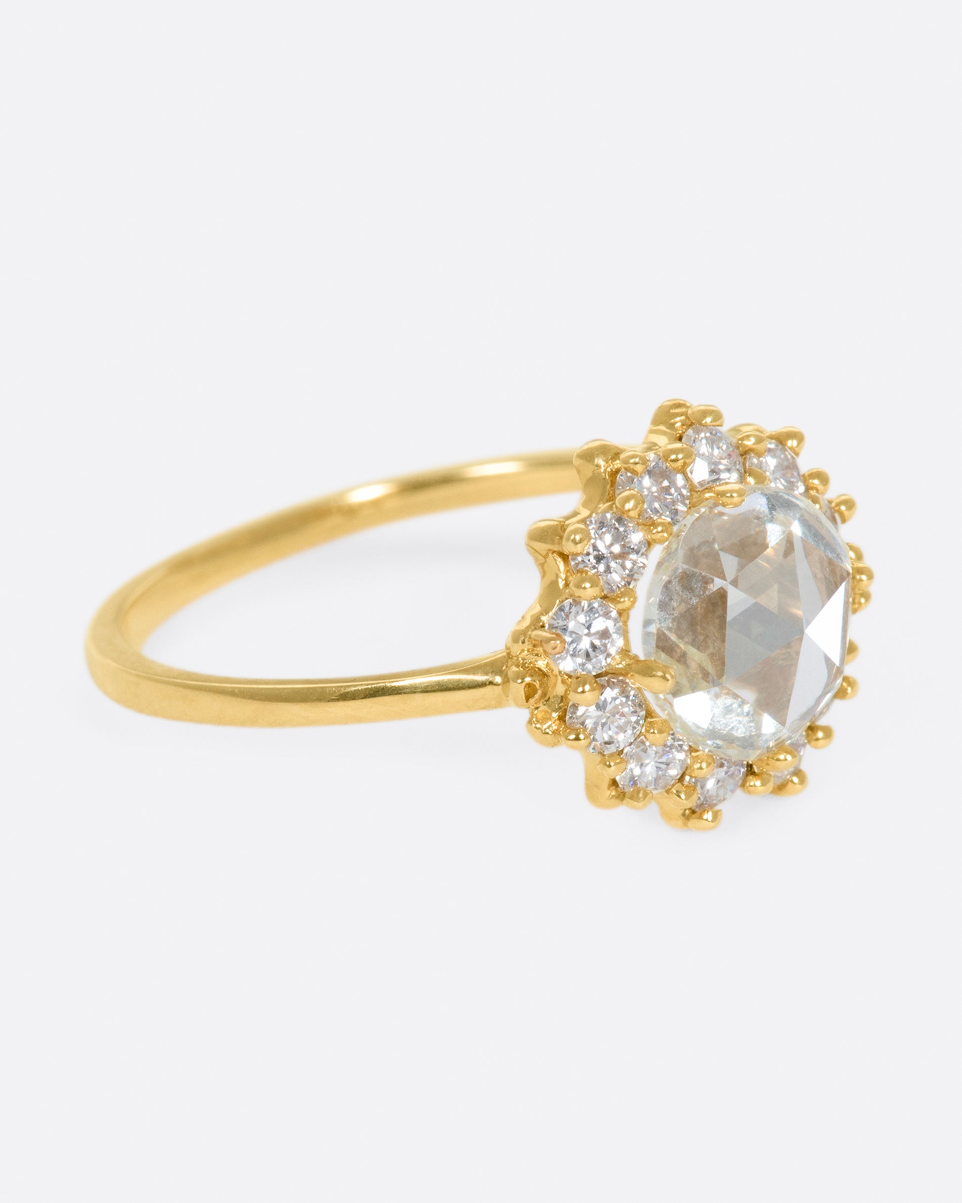 This light champagne, rose cut diamond is surrounded by a diamond halo, giving it the illusion of a shining sun.