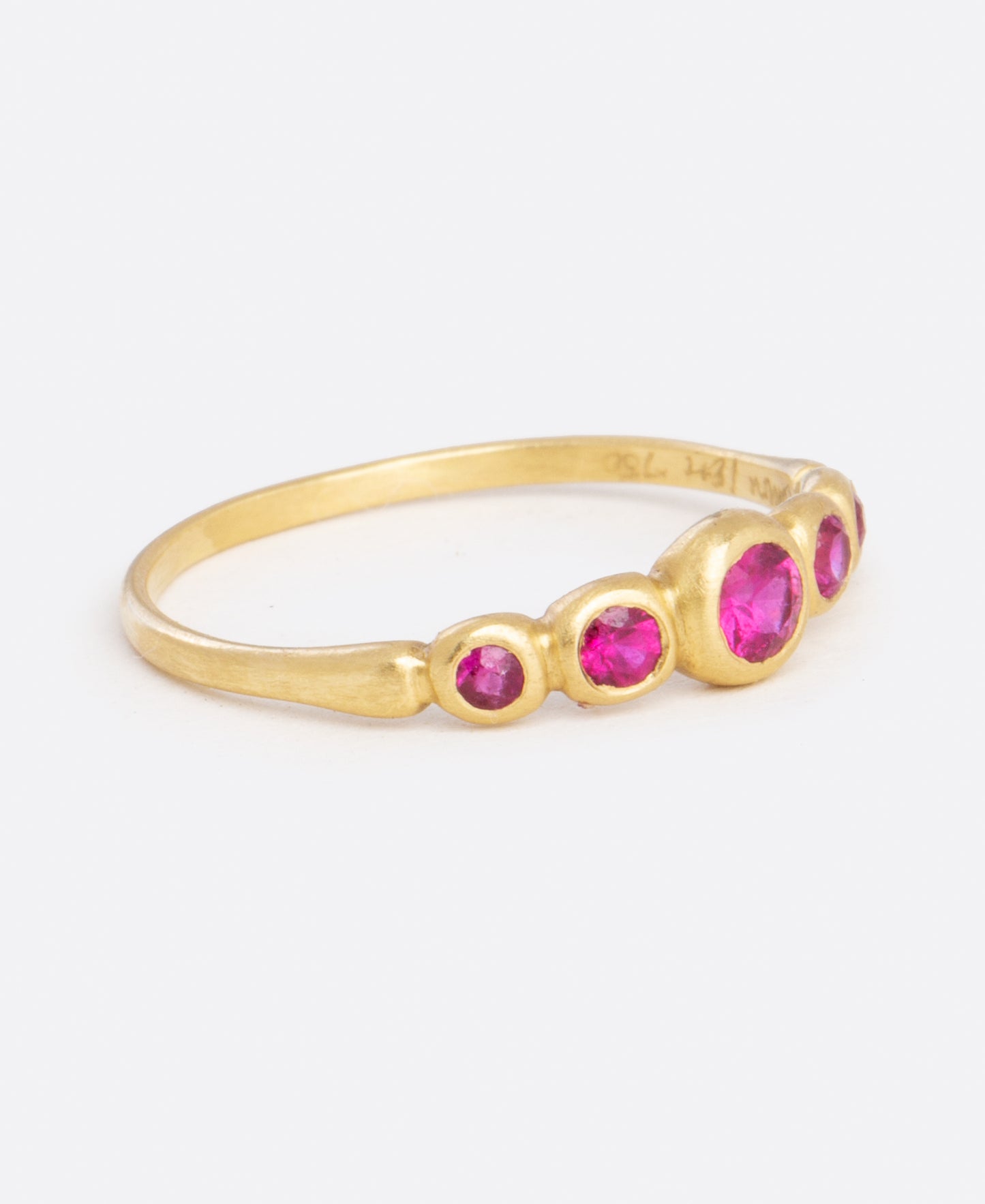 A classic combo, ruby and yellow gold, make up this ring with graduated sizes of stones.